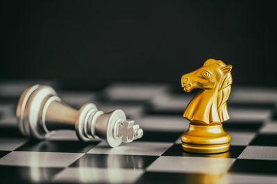 Close-up of chess pieces on board against black background