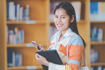 Portrait of woman holding smart phone