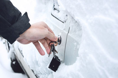 Cropped image of hand opening car door with key