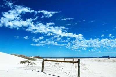 Scenic view of beach against blue sky