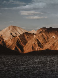 Scenic view of mountain range against cloudy sky