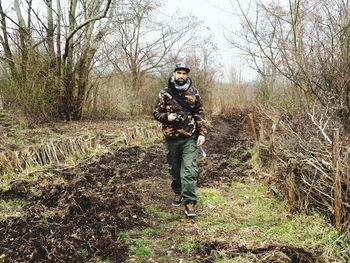 Full length of man standing on field in forest