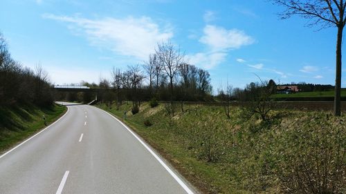 Road amidst field against sky