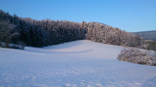 Scenic view of snow covered field against clear sky