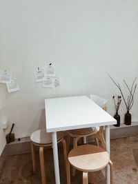 Empty chairs and table against wall at home