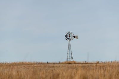 Windmill on field against sky