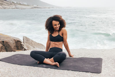 Portrait of young woman sitting at beach