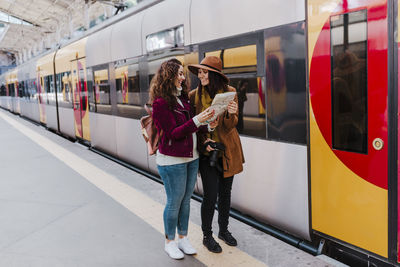 Friends reading map at railroad station platform