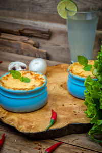 Pots with mushroom julienne on a wooden board.