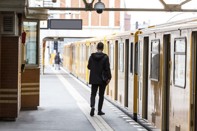 Rear view of man walking on train