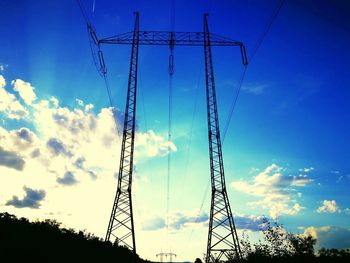 Low angle view of electricity pylon against blue sky