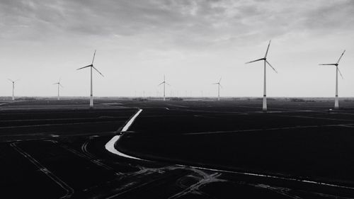 Wind turbines on land against sky