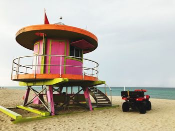 Lifeguard hut at beach against sky