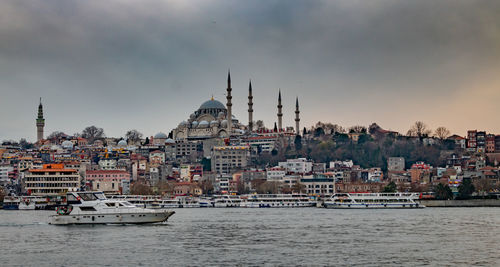 Boats in sea against cloudy sky