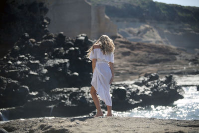 Rear view of woman standing on beach