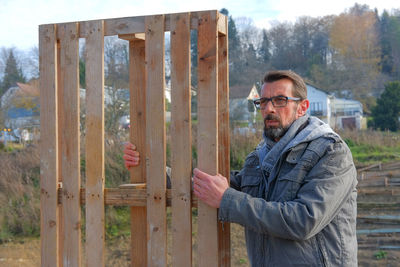 Side view of  man standing on wood