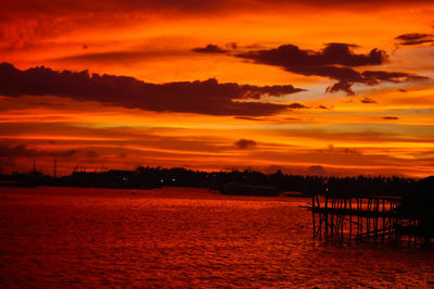 Scenic view of sea against dramatic sky during sunset