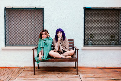 Portrait of sisters sitting on bench