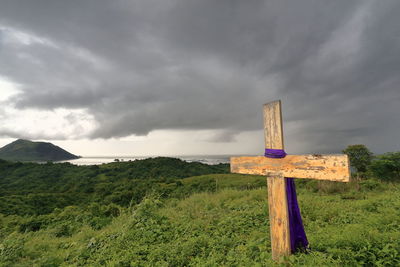 Cross on land against sky