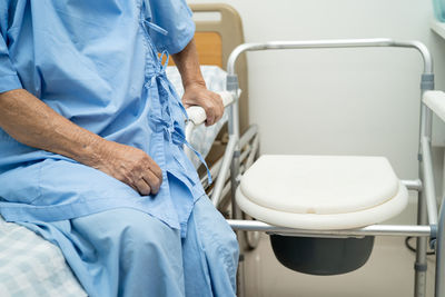 Midsection of woman sitting in bathroom