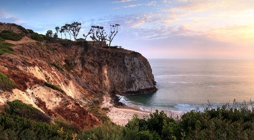 Scenic view of sea by cliff against sky