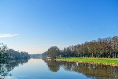 Scenic view of river fulda against blue sky
