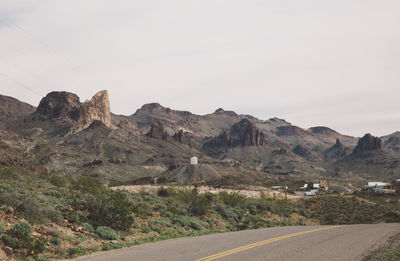 Road by mountains against sky