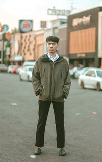 Portrait of young man standing on street in city