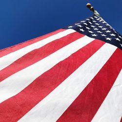 Low angle view of flag against blue sky