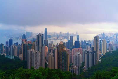 Modern buildings in city against cloudy sky