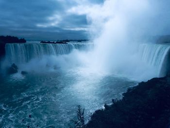 Scenic view of waterfall against sky