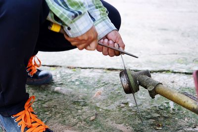 Low section of man cutting water pipe