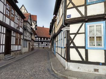 Empty alley amidst buildings against sky