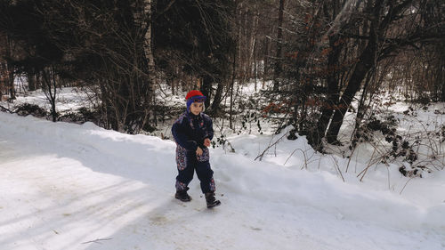 Full length of boy walking on road during winter