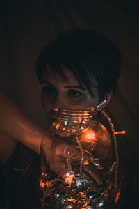 Portrait of young woman holding cigarette in the dark