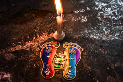 Close-up of illuminated candles on wood