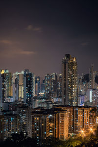 Illuminated buildings in city against sky at night