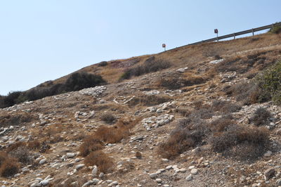 Low angle view of people on rock against sky