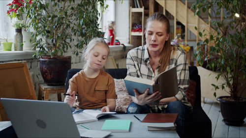 Mother teaching daughter at home