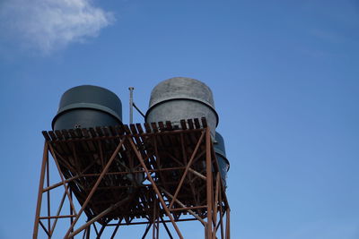 Low angle view of water tower against blue sky