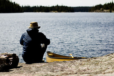 Rear view of man on boat in river