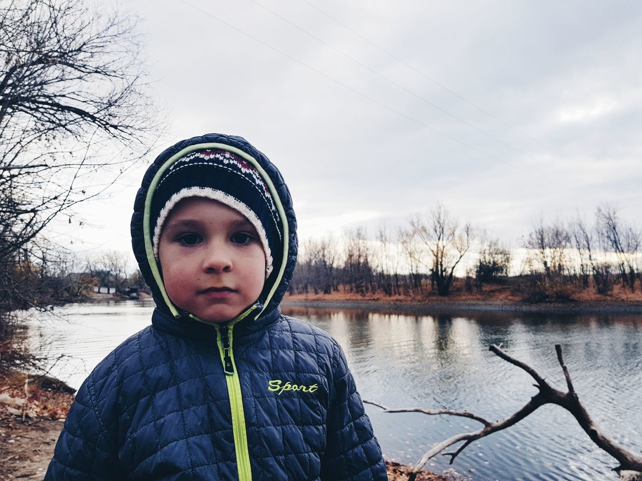 portrait, winter, one person, real people, clothing, sky, nature, looking at camera, warm clothing, lifestyles, cold temperature, front view, leisure activity, water, tree, snow, lake, outdoors