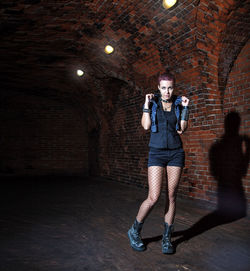 Portrait of young female model standing in tunnel