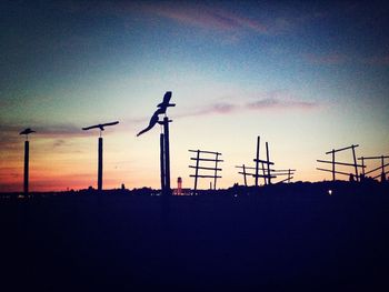 Traditional windmill against sky at sunset