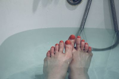 Low section of young woman in bathtub