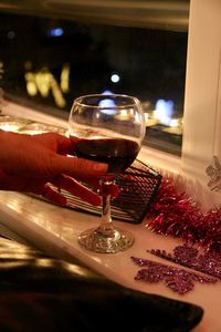 Close-up of hand holding drink on table