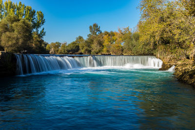 Scenic view of waterfall against sky