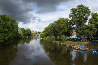 Scenic view of river amidst trees against sky