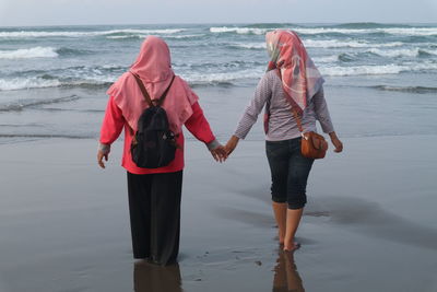 Rear view of woman standing on beach