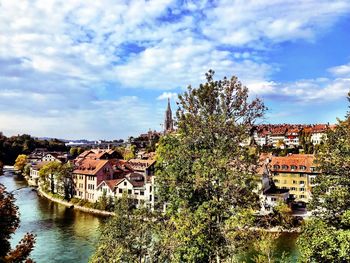 View of townscape by river against sky